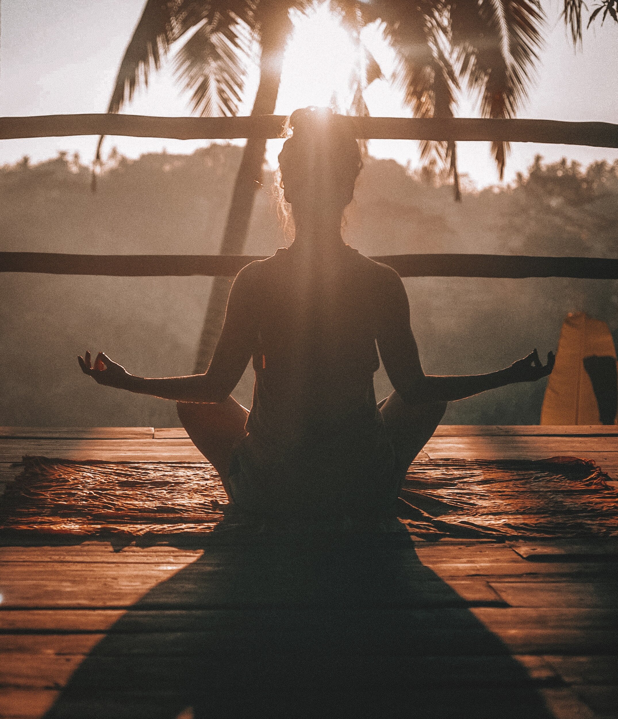 Female meditating on a yoga deck in paradise
